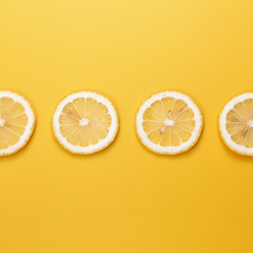 Кружки лимона, желтый фон