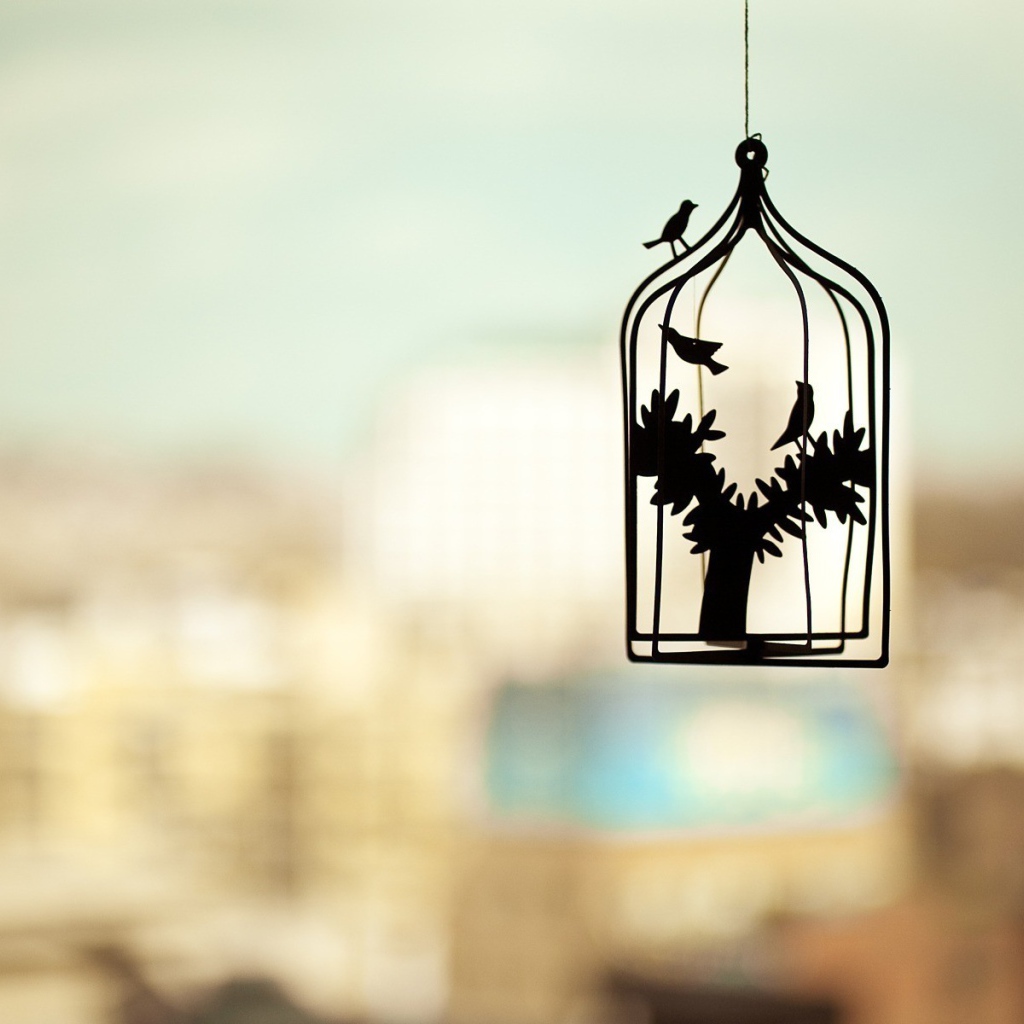 Силуэт клетки для птиц на нечетком фоне