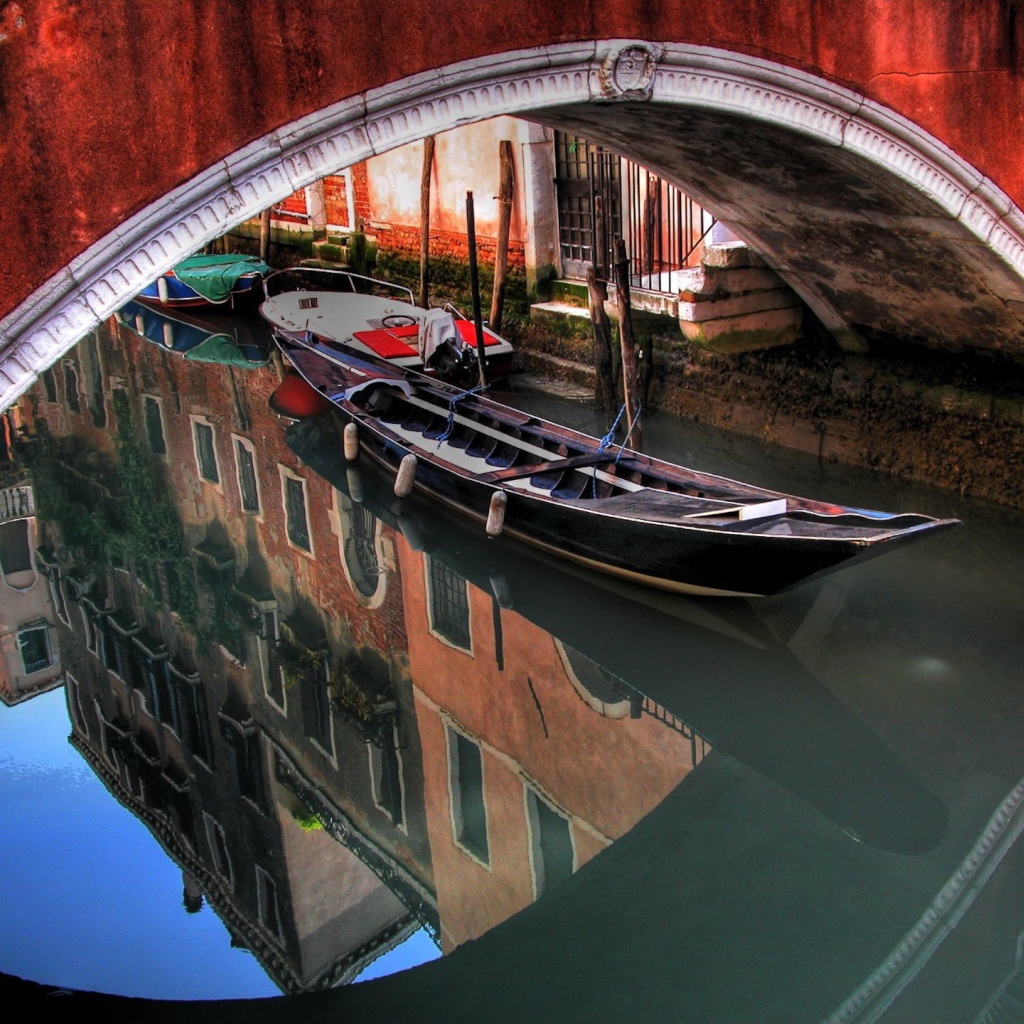 Лодка под красным мостом в Венеции