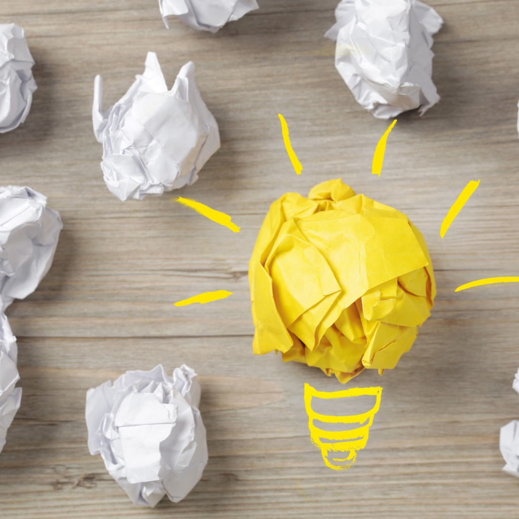 Комок желтой бумаги среди белых