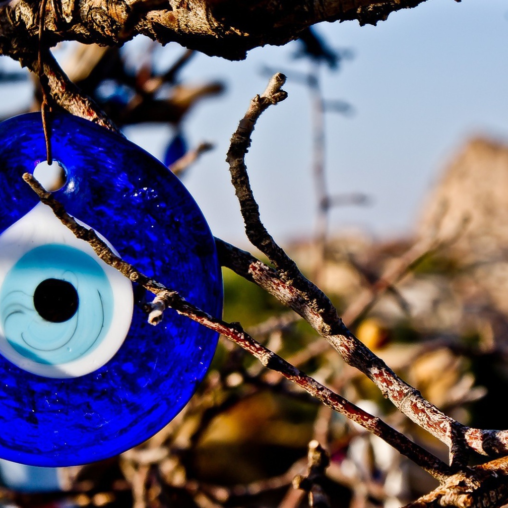 Оберег из синего стекла на дереве