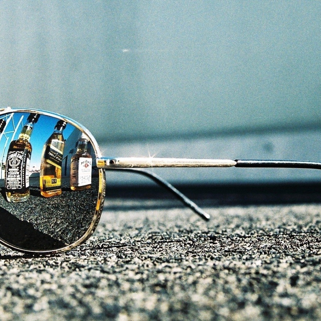 Бутылки с алкоголем отражаются в очках