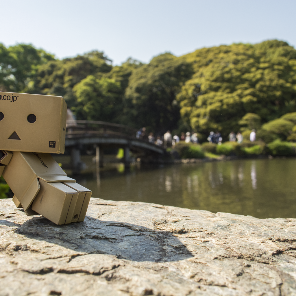 Картонный человечек на камне в саду