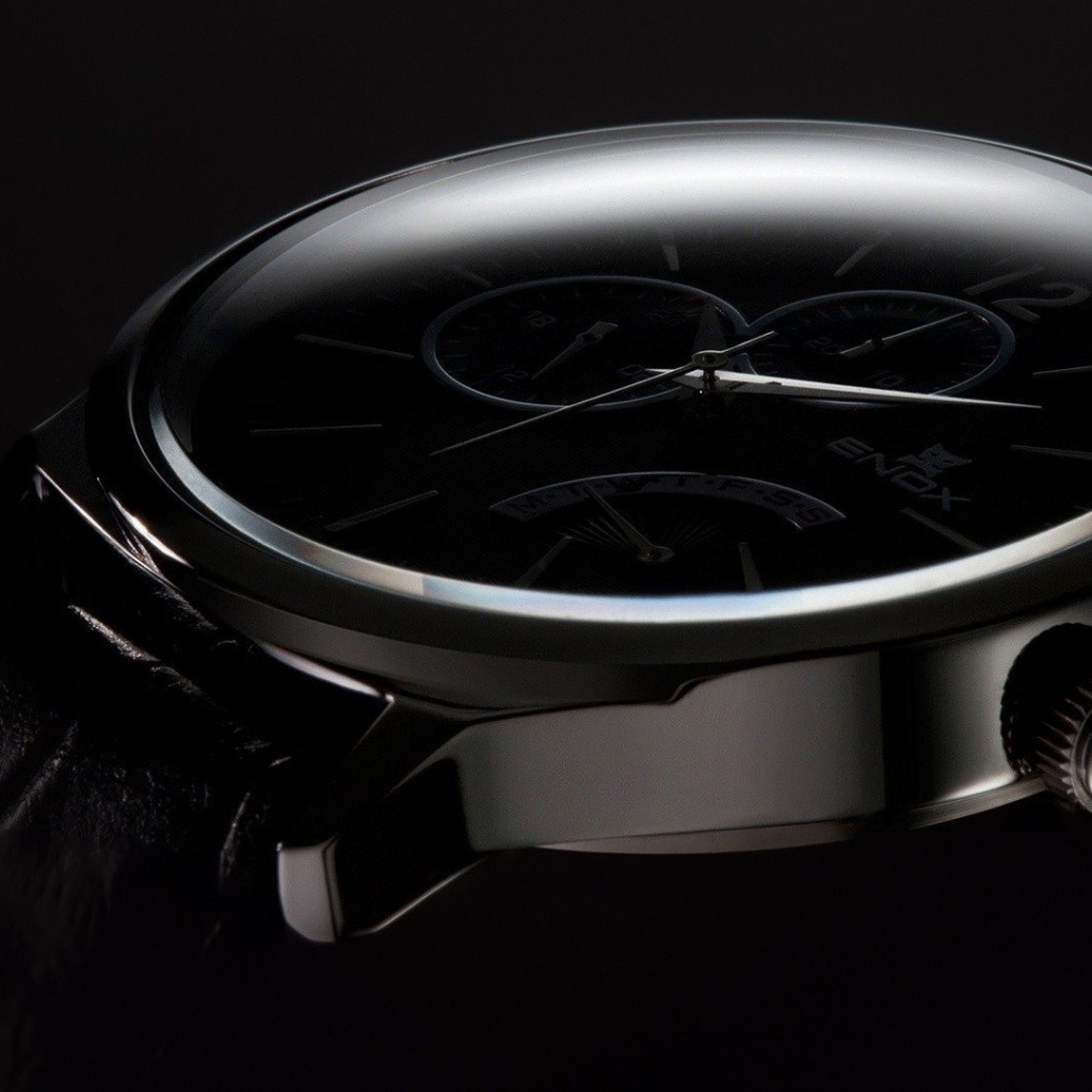 Дорогие черные часы на черном фоне