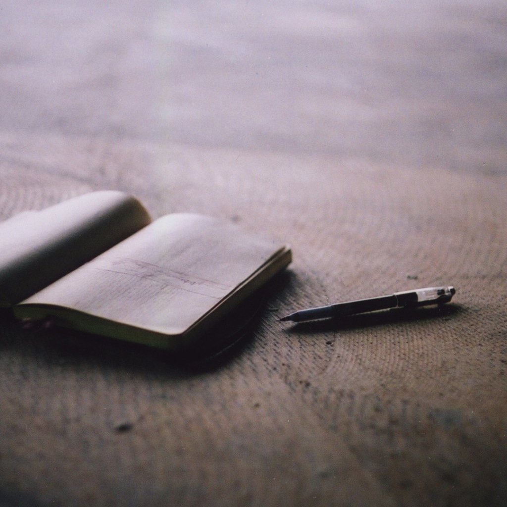 Записная книжка и ручка на полу