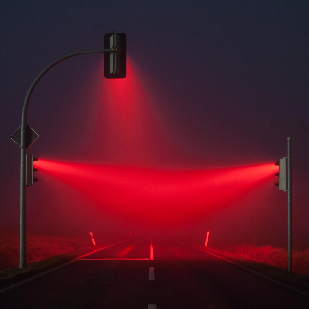 Красные светофоры освещают туман