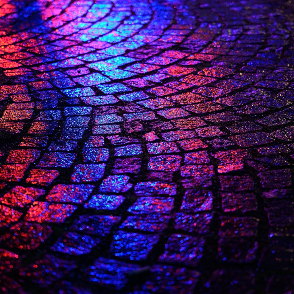 Блики ночных огней на брусчатке улицы