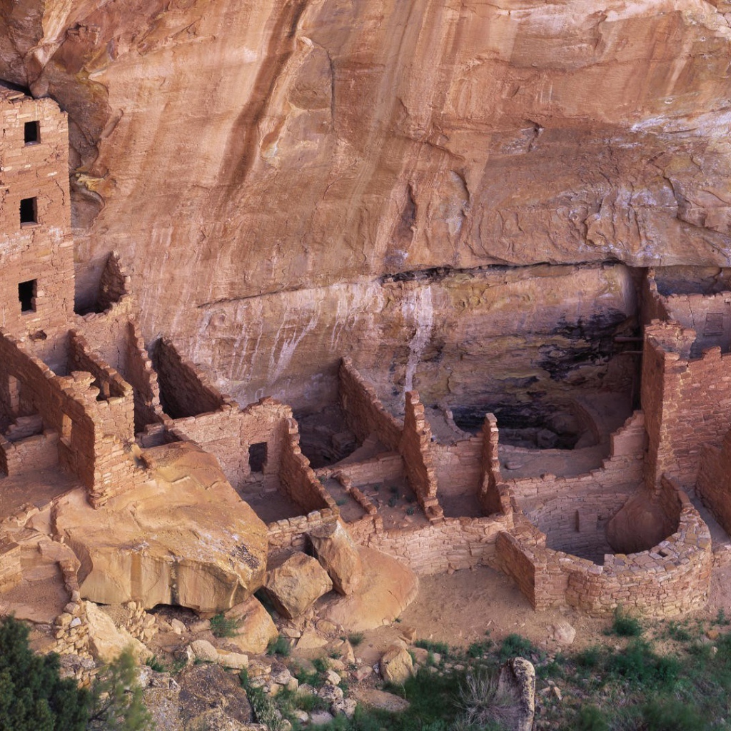 Руины каменных домов под скалой