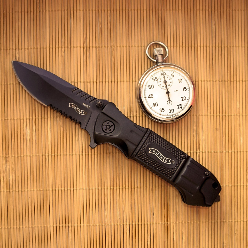 Часы и нож на бамбуковом коврике