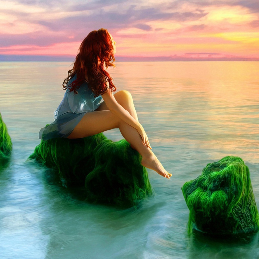 Русалка на зеленых камнях смотрит на закат