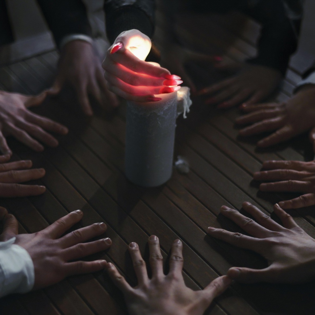 Люди вызывают духа при помощи свечи