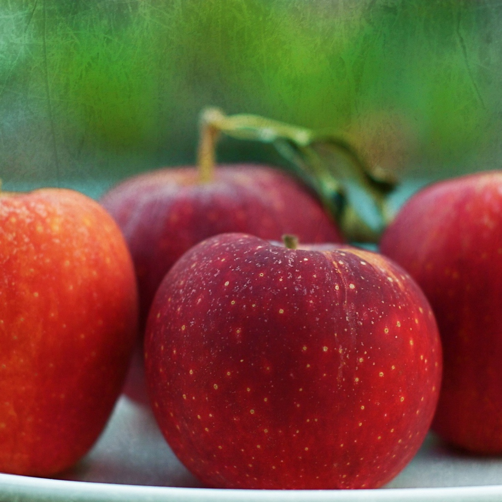 Четыре красных яблока на тарелке