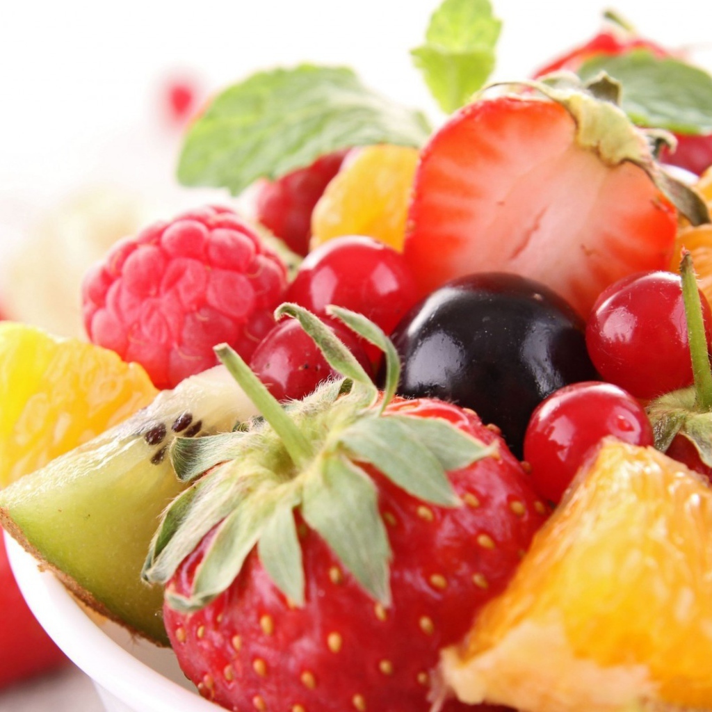 Кусочки спелых фруктов и ягоды на тарелке