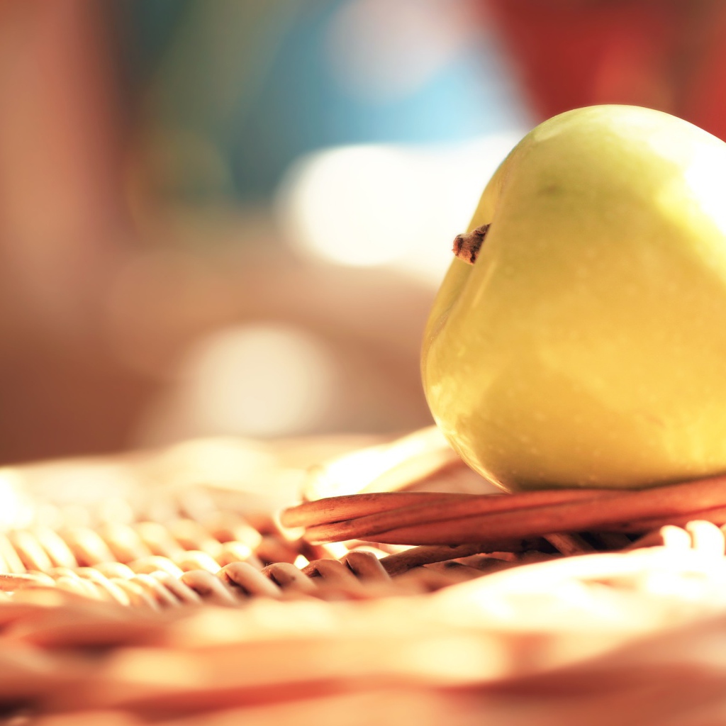 Белое яблоко на плетеной подставке