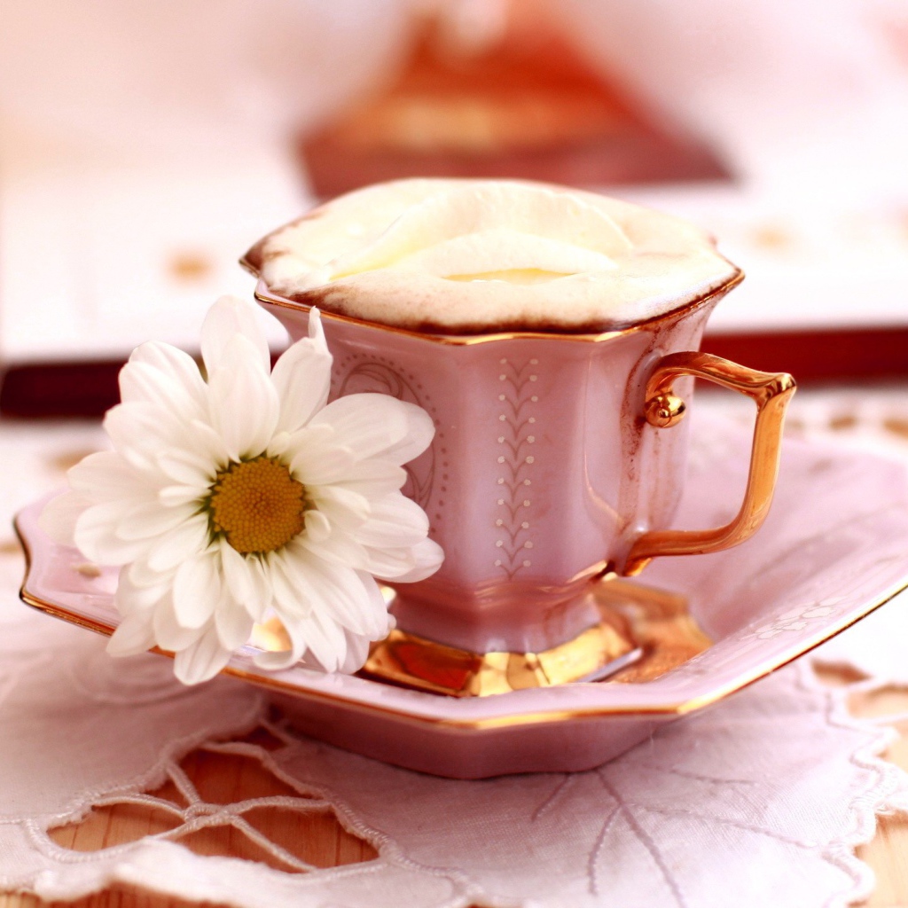 Кофе с пенкой и ромашка на блюдце