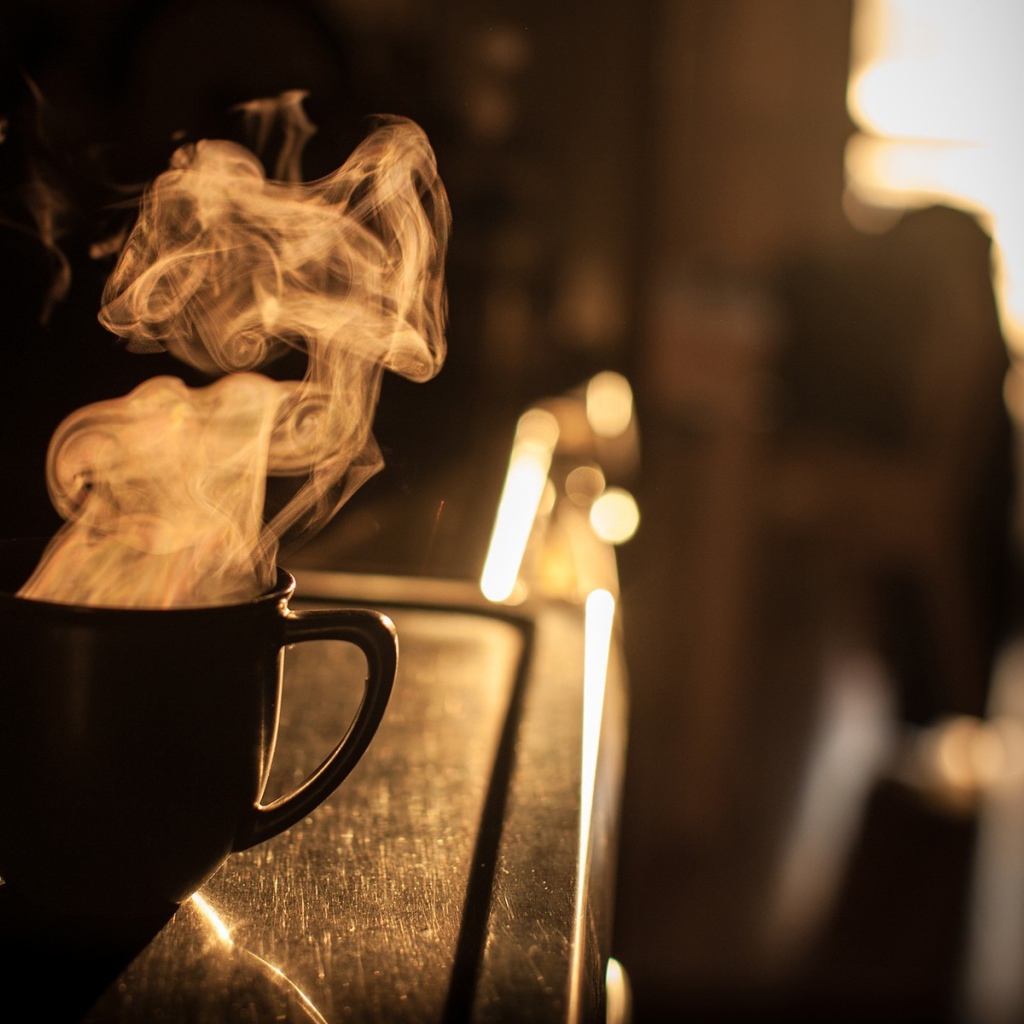 Пар из чашки кофе на закате