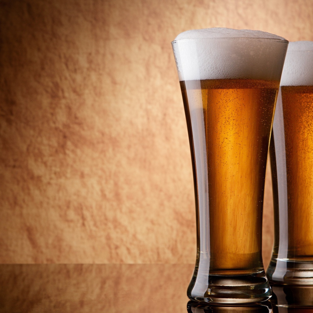 Два бокала пива, коричневый фон
