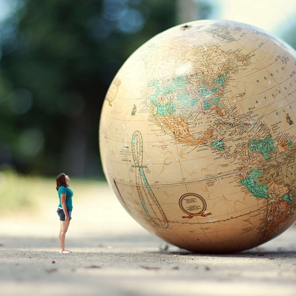 Девушка стоит перед огромным глобусом