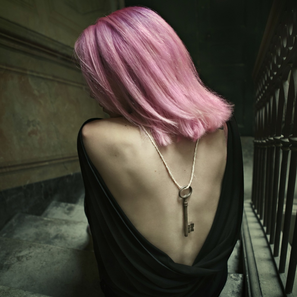 Девушка с розовыми волосами сидит на лестнице