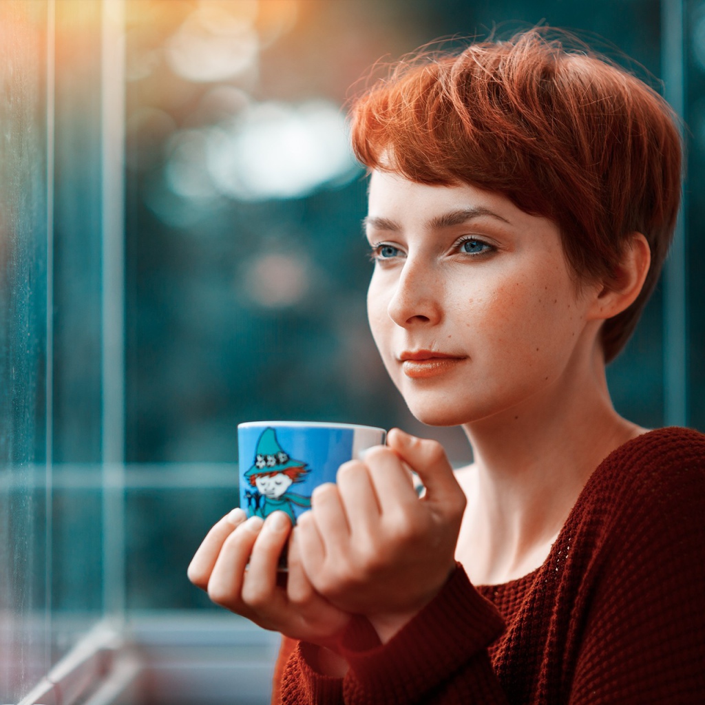 Девушка с короткими волосами пьет кофе