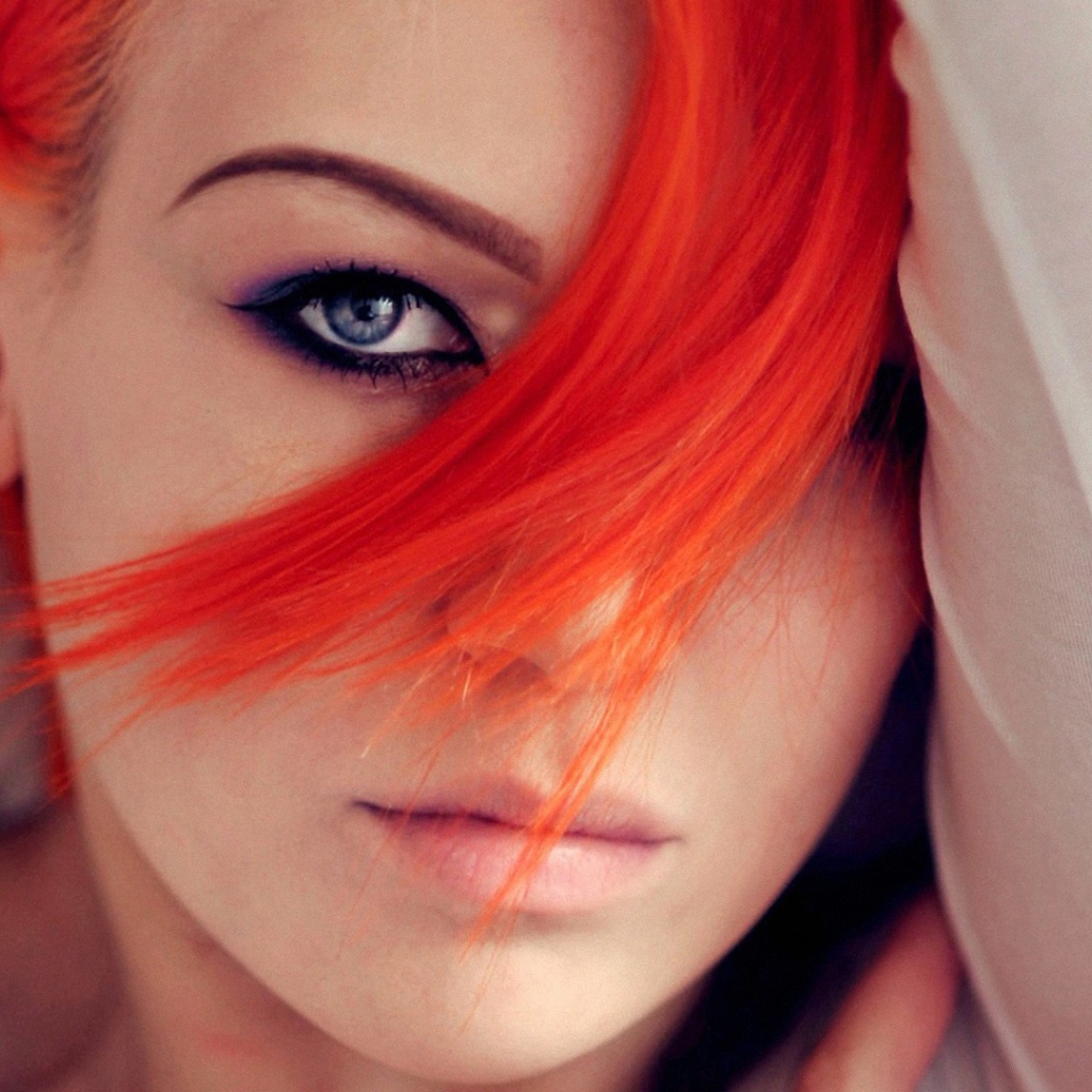 Прядь оранжевых волос на лице у девушки