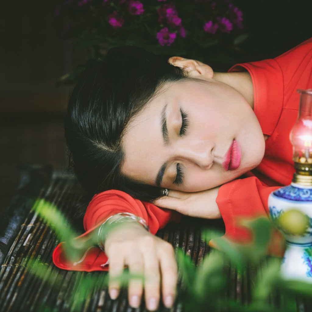 Азиатка спит положив голову на руки