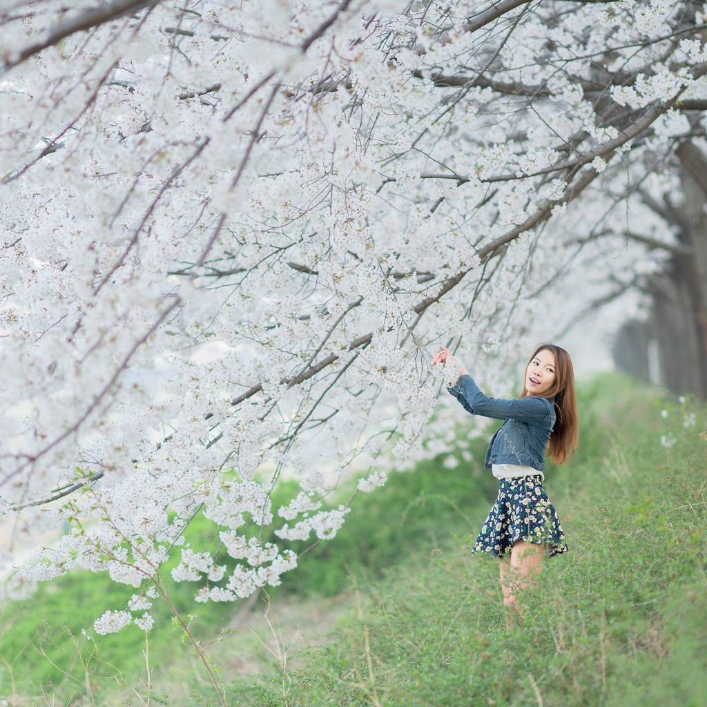 Азиатская девушка радуется весенним цветам