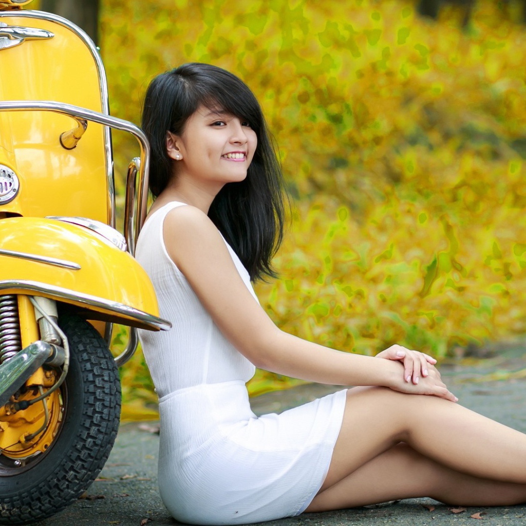 Азиатская девушка у желтого мотороллера