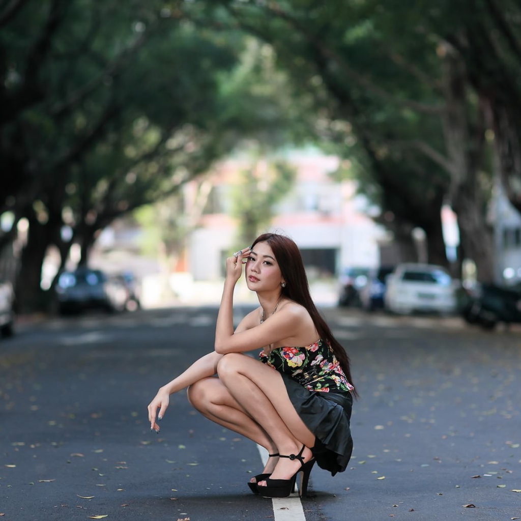 Азиатская девушка сидит на корточках