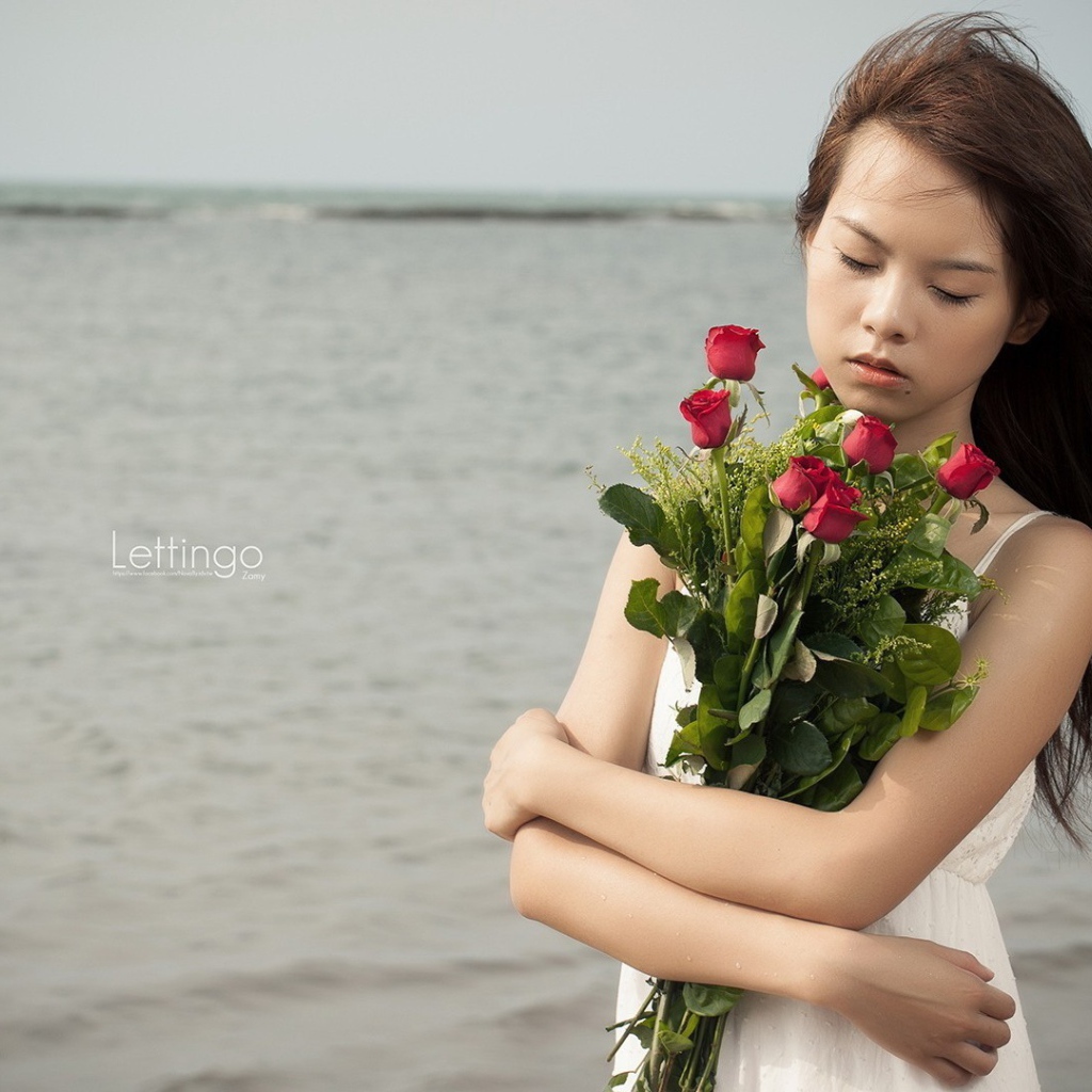 Азиатка держит в руках букет роз