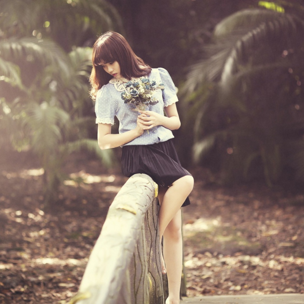 Азиатка с букетом на поручне моста