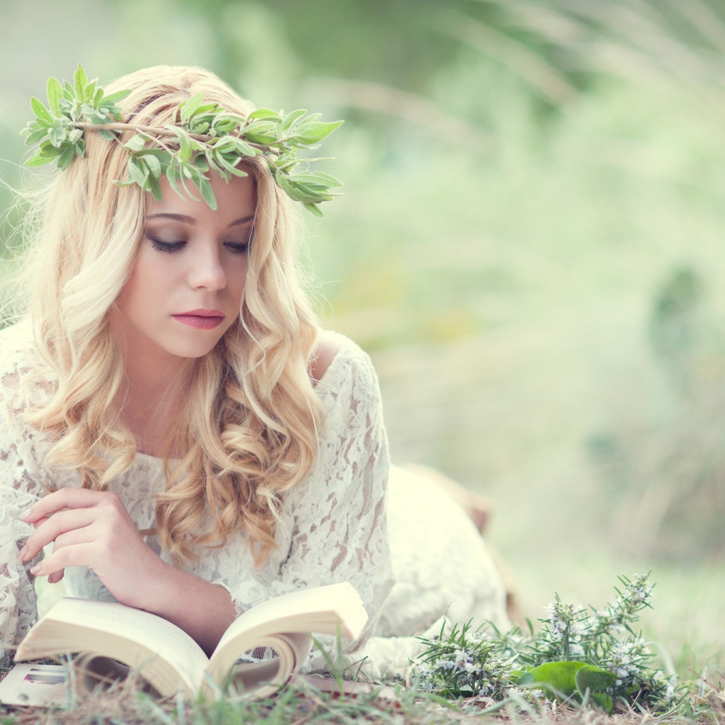 Блондинка в зеленом венке читает книгу