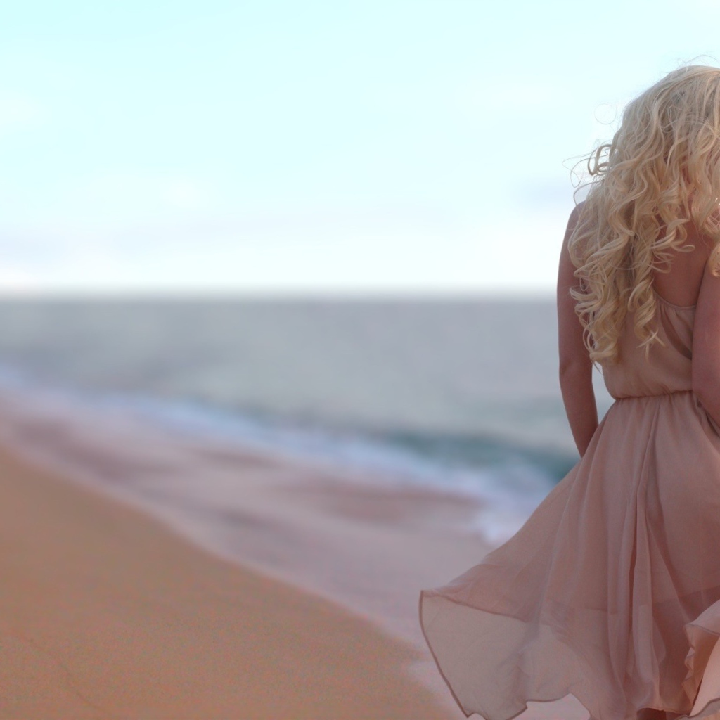 Блондинка в легком платье на пляже