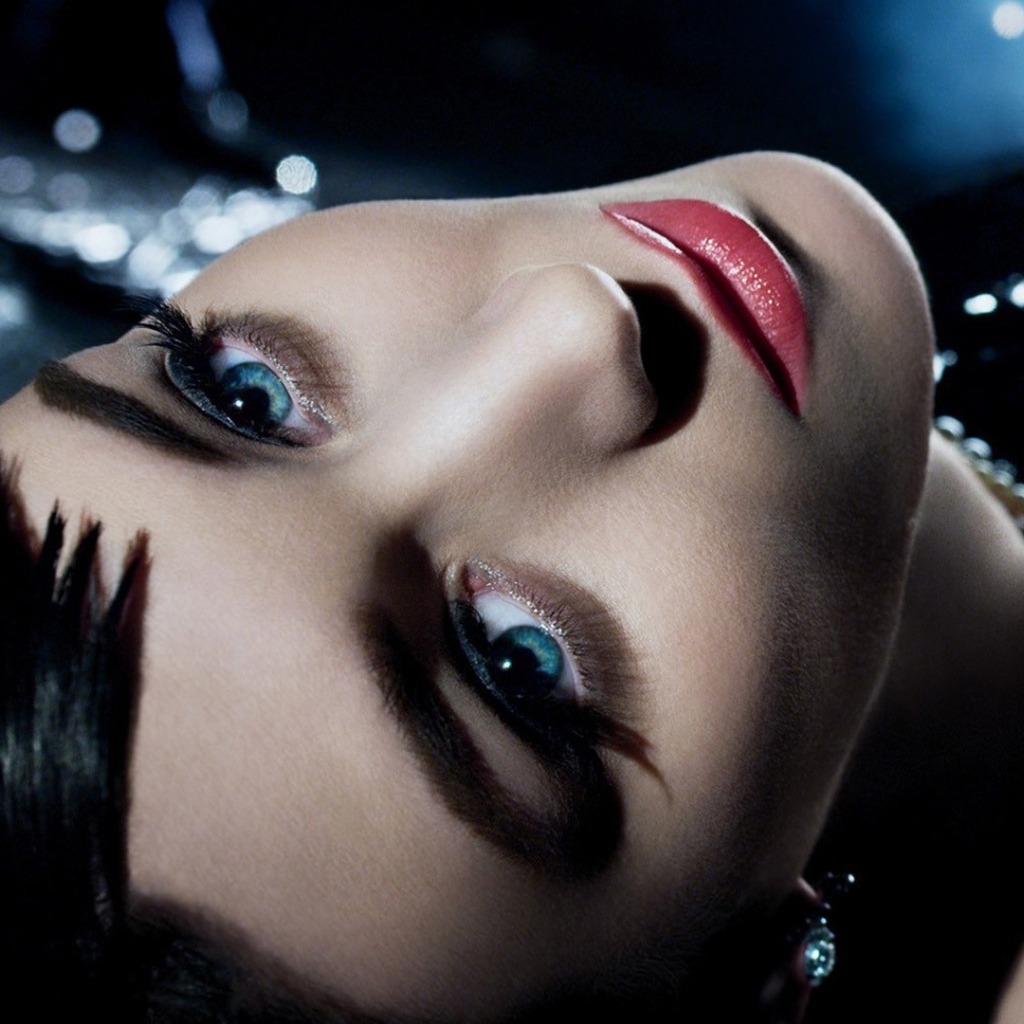 Голубоглазая брюнетка лежит в черном платье