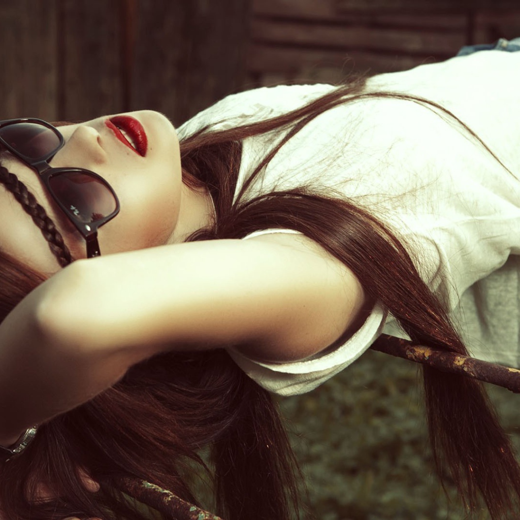 Брюнетка в темных очках смотрит в небо