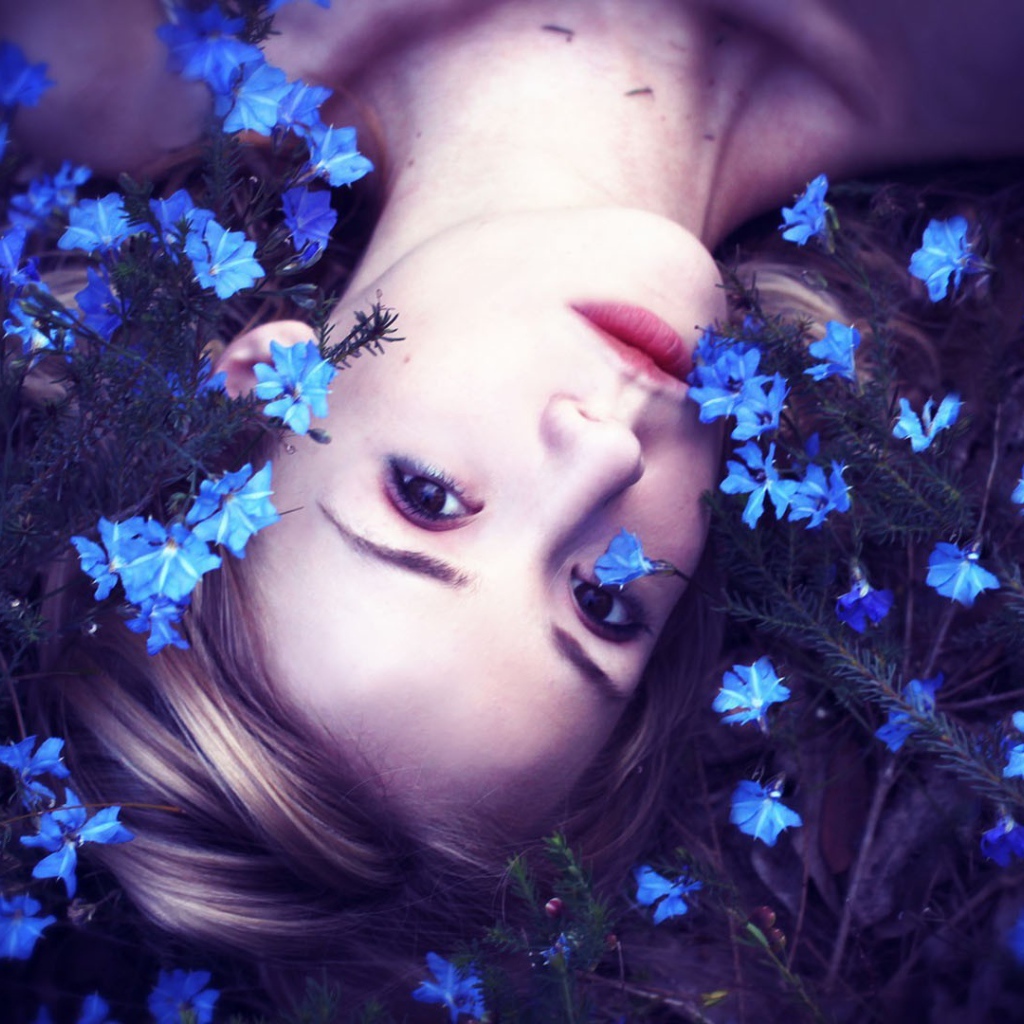 Девушка среди маленьких голубых цветов