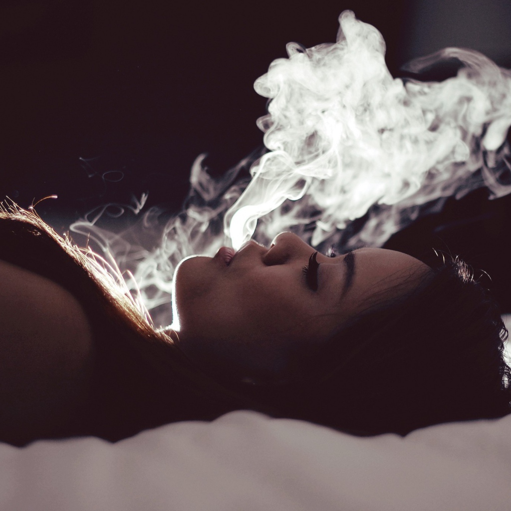 Девушка выпускает дым изо рта