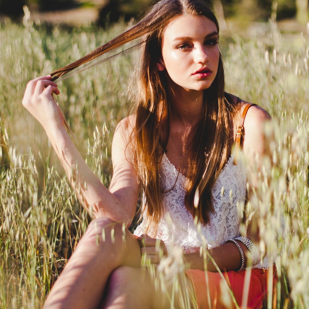 Девушка держит в руке прядь волос