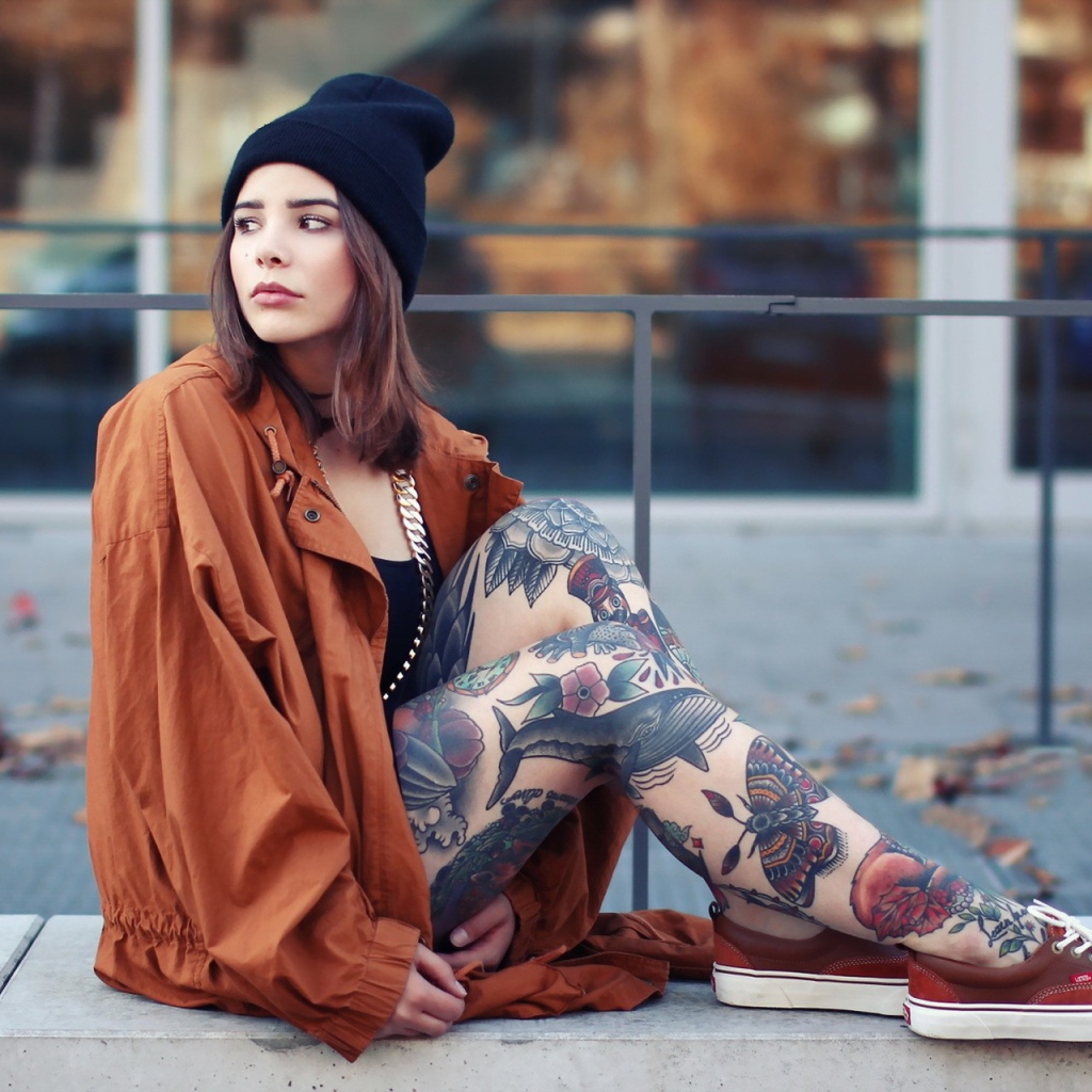 Девушка в шапке с тату на ногах