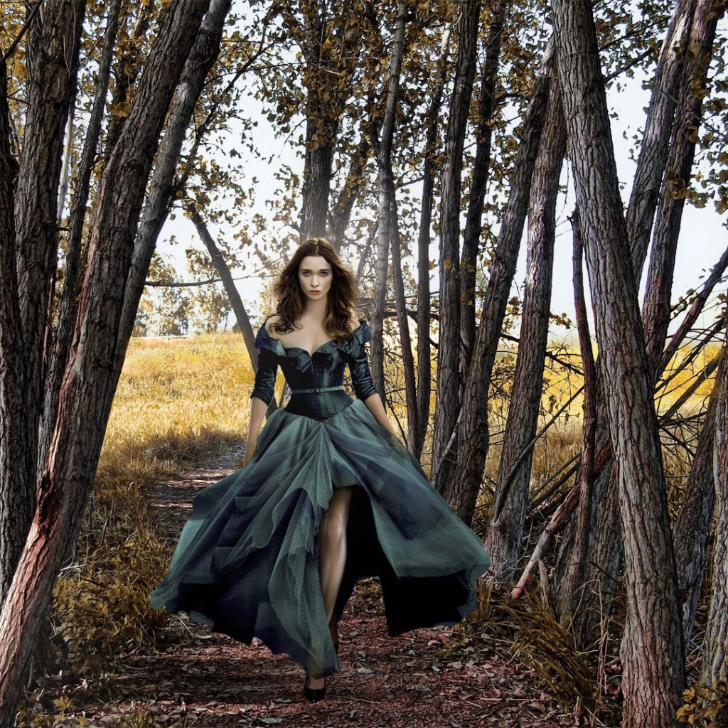 Девушка в черном платье среди деревьев