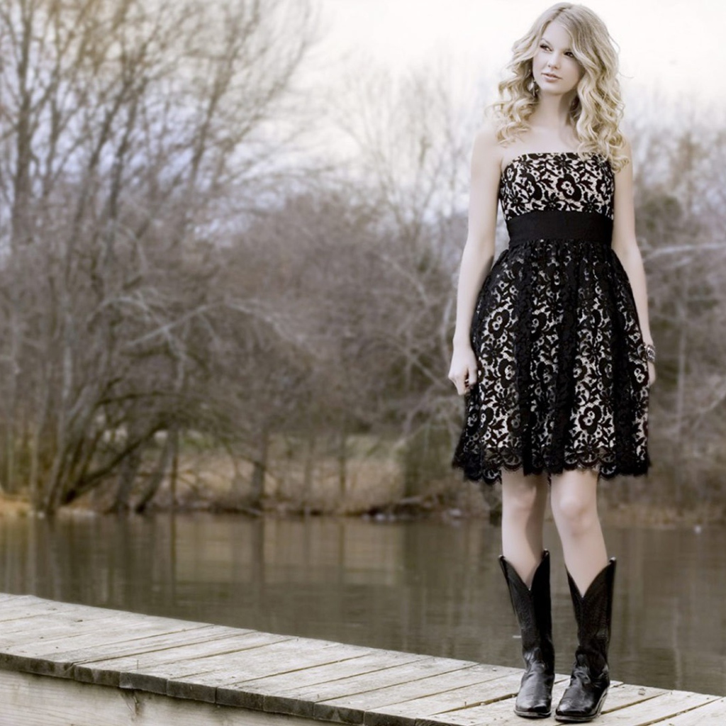 Девушка в черном платье и кожаных сапогах