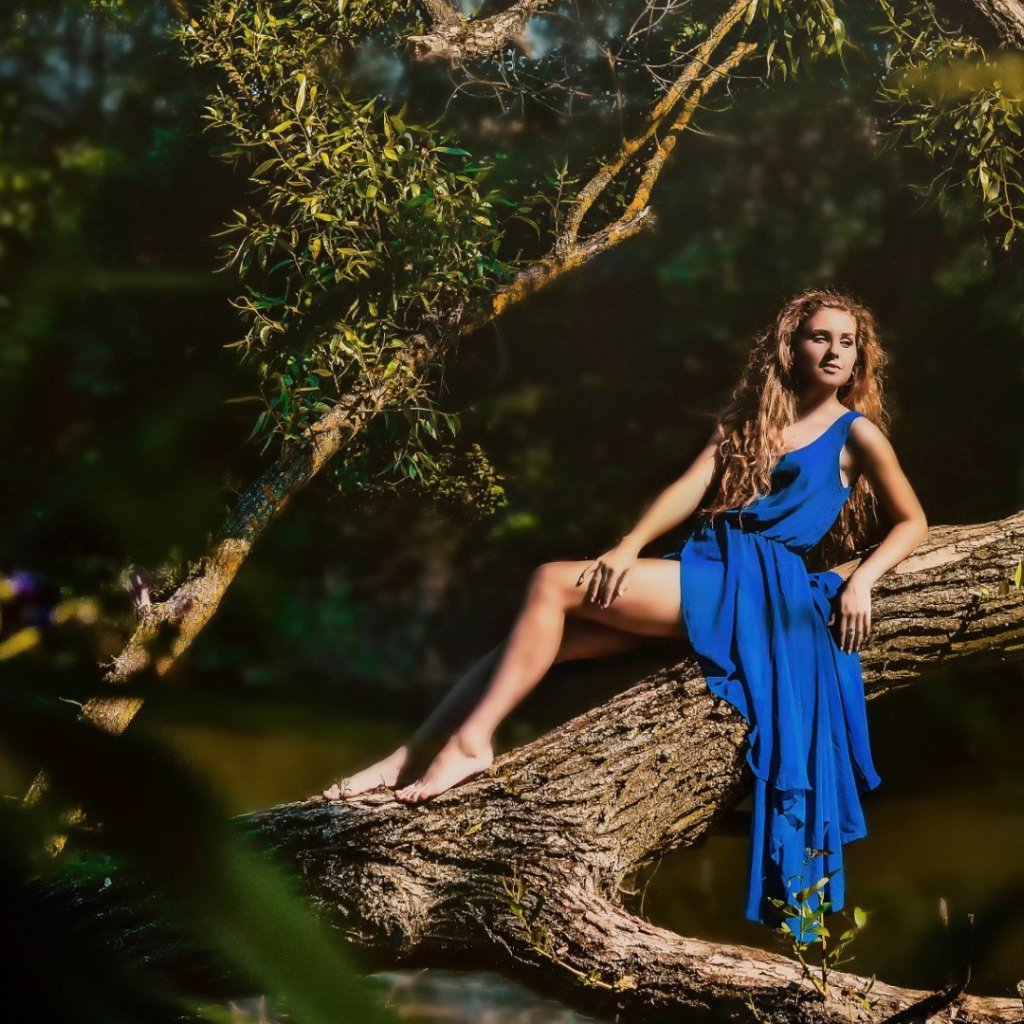 Девушка в голубом платье на дереве