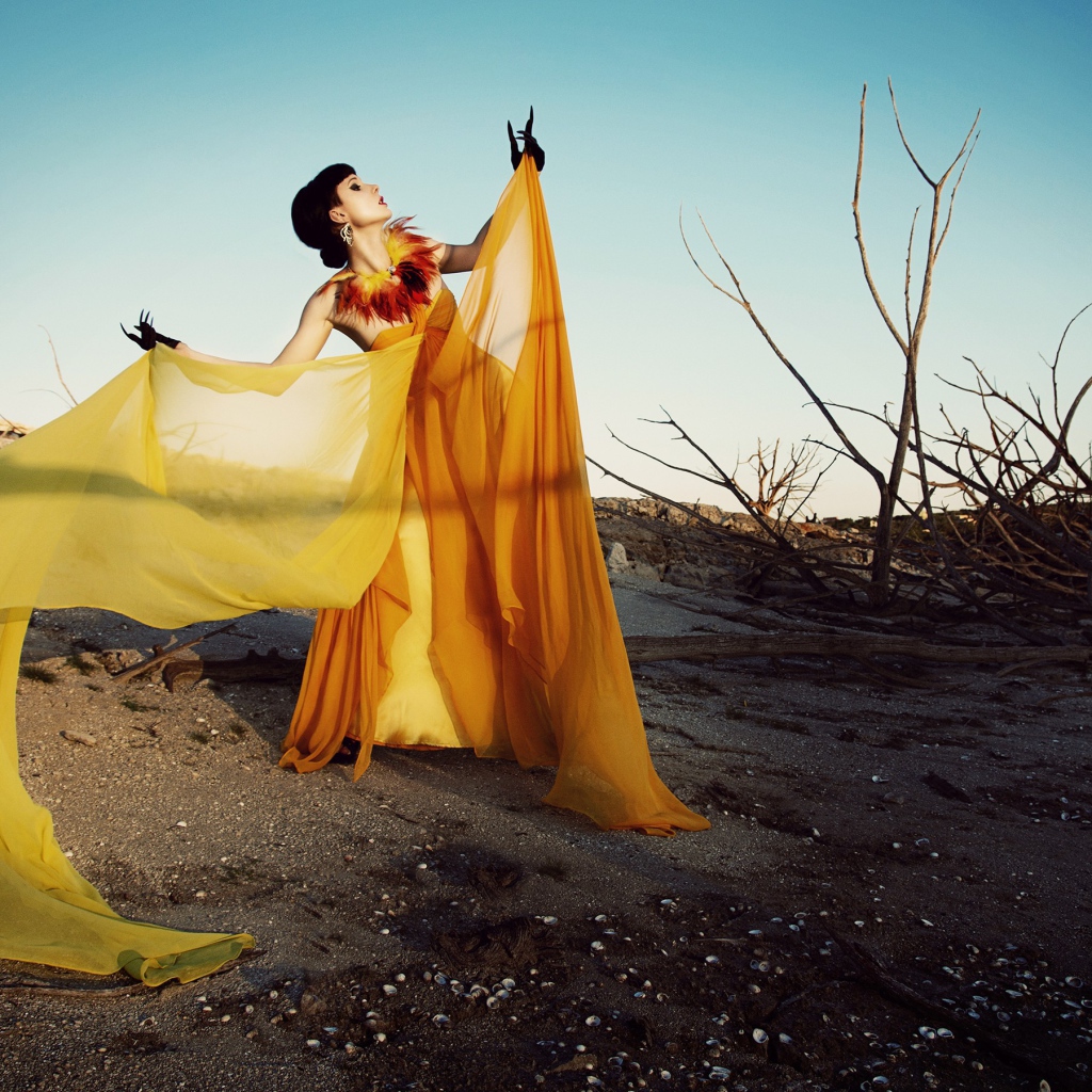 Девушка в оранжевом позирует в пустыне