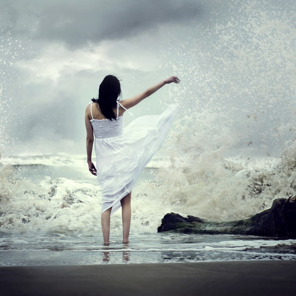 Девушка в белом платье среди брызг прибоя