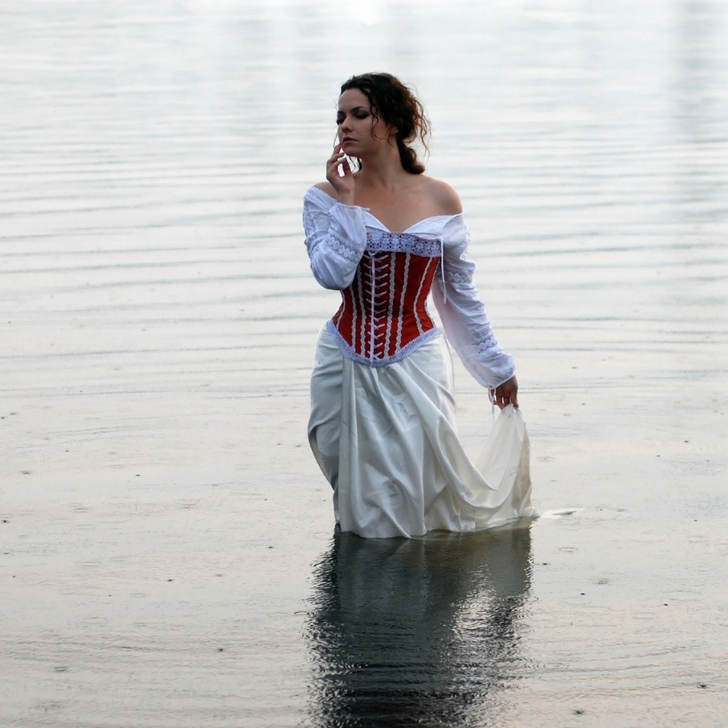 Девушка в белом платье стоит в воде