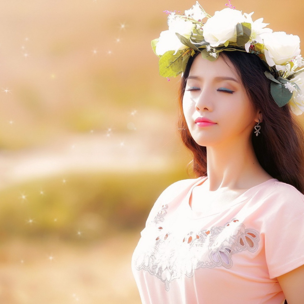 Девушка в белом венке прикрыла глаза