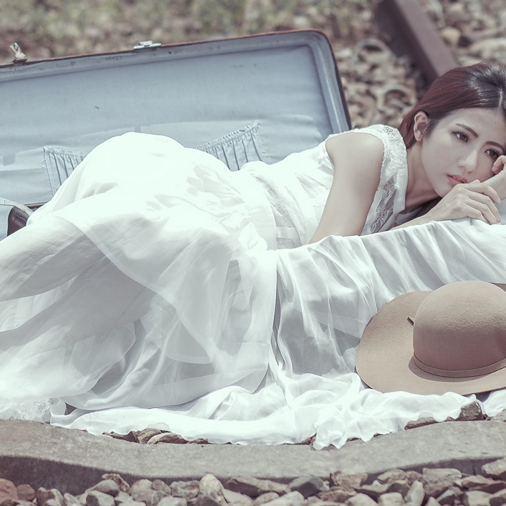 Девушка лежит в чемодане на рельсах