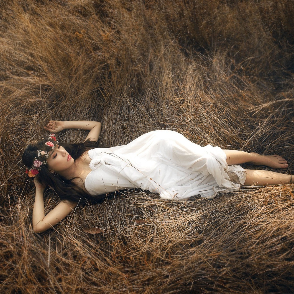 Девушка лежит на сухой траве