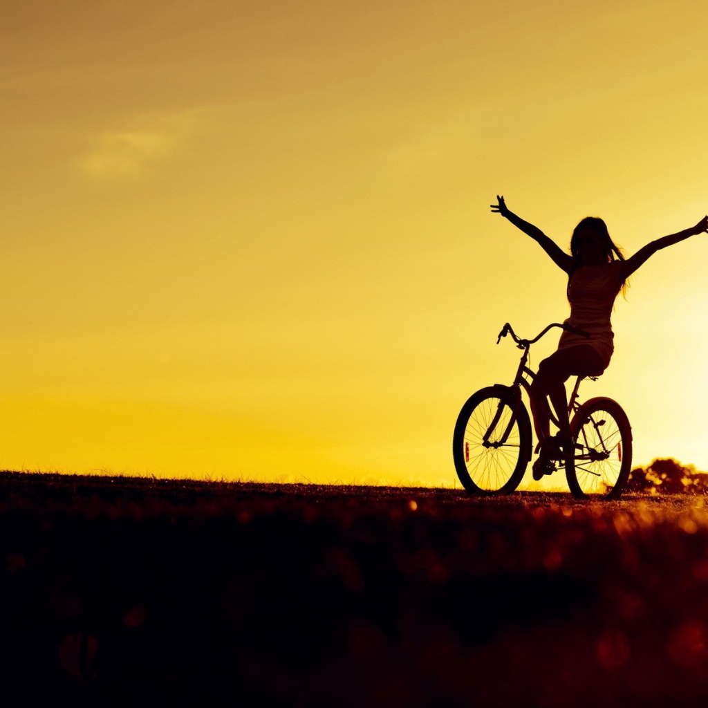 Девушка на велосипеде на фоне заката