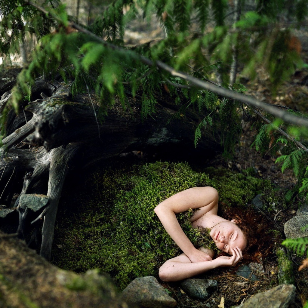 Девушка спит укрывшись мхом в лесу